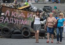 Люди идут вдоль баррикад на площади Независимости в Киеве Люди идут вдоль баррикад на площади Независимости в Киеве