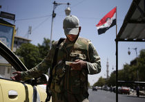 Сирийский военный проверяет документы на блокпосту в Дамаске Сирийский военный проверяет документы на блокпосту в Дамаске