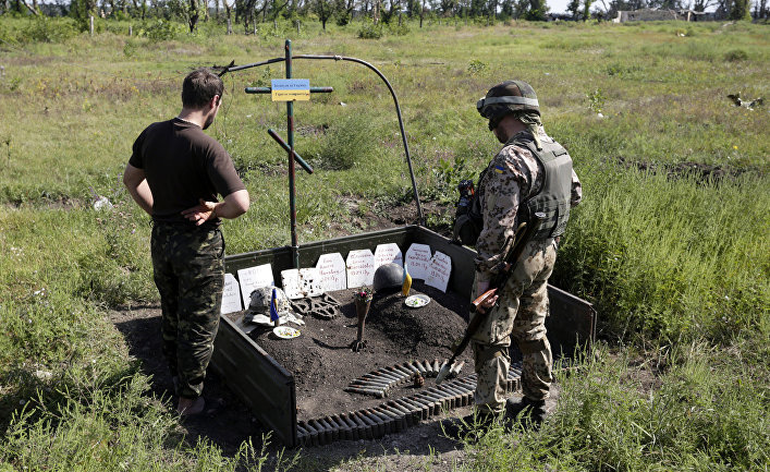 Украинские военные возле импровизированного мемориала их товарищам, погибшим здесь же, рядом с Авдеевкой, Донецкая область