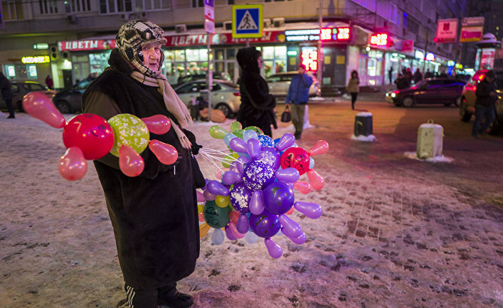 Пожилая женщина продает цветные шары в центре Москвы