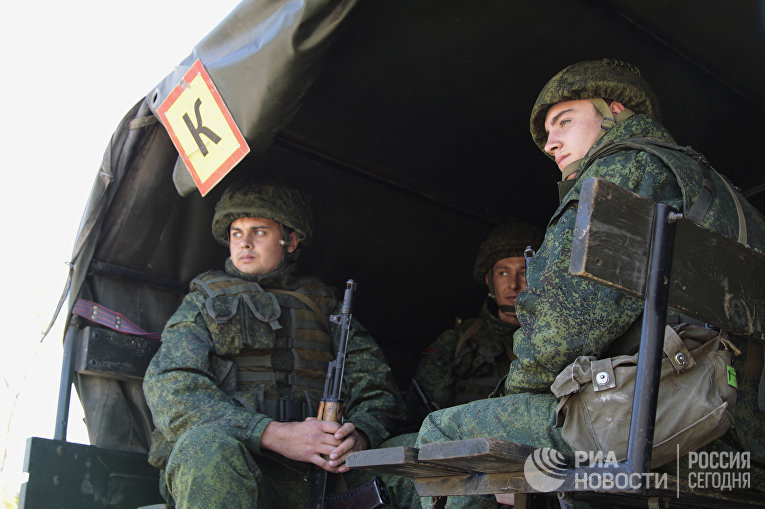 Военнослужащие ожидают отвода техники в районе пропускного пункта «Станица Луганская» в Донбассе