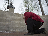 Мужчина кланяется бюсту российского президента Владимира Путина Мужчина кланяется бюсту российского президента Владимира Путина