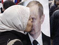 Сирийская женщина целует портрет президента РФ Владимира Путина Сирийская женщина целует портрет президента РФ Владимира Путина