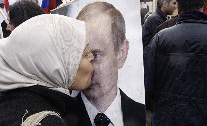 Сирийская женщина целует портрет президента РФ Владимира Путина Сирийская женщина целует портрет президента РФ Владимира Путина