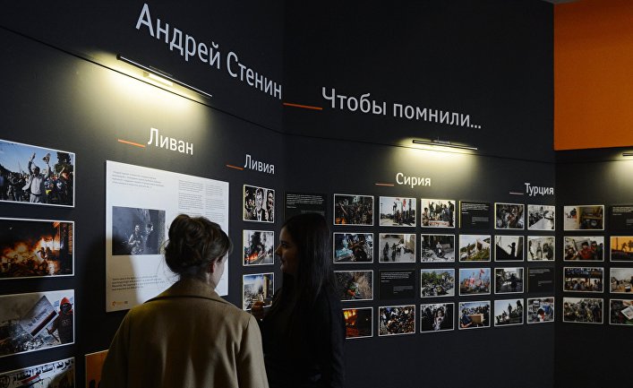 Сотрудники МИА «Россия сегодня» у экспозиции фотографий корреспондента Андрея Стенина