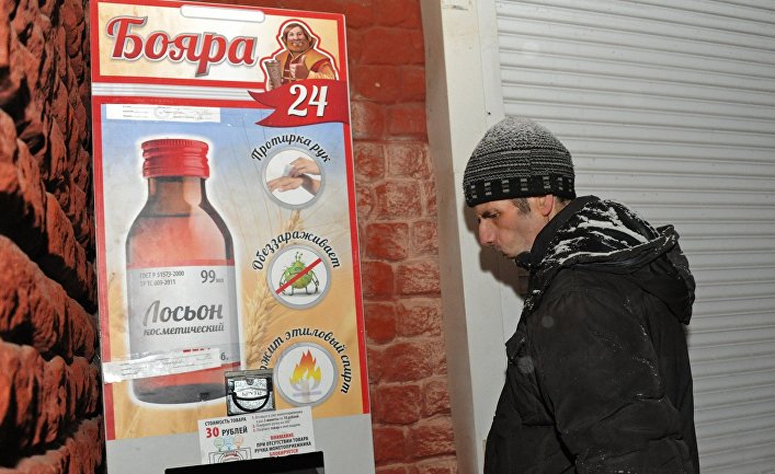 Мужчина у автомата по продаже спиртосодержащего средства с боярышником