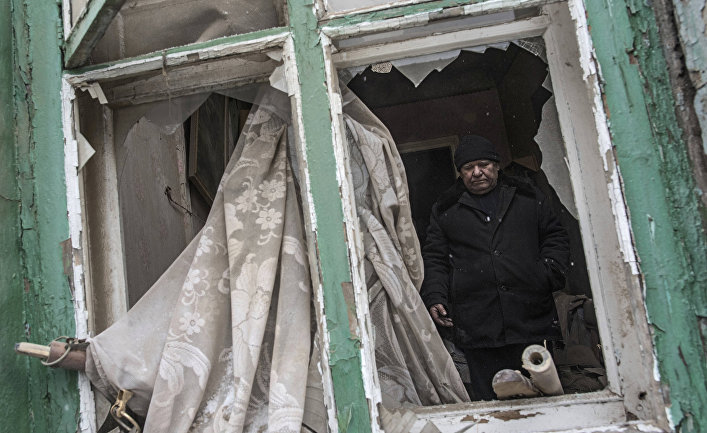 Мужчина в своем доме, поврежденном в результате обстрела