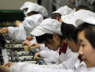 Работники на производственной линии завода Foxconn в Шэньчжэнь Работники на производственной линии завода Foxconn в Шэньчжэнь