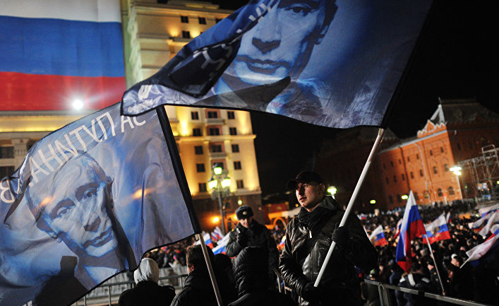 Участники санкционированного митинга в поддержку кандидата в президента РФ Владимира Путина на Манежной площади