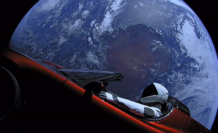 Личный автомобиль главы SpaceX Илона Маска красный кабриолет Tesla Roadster, выведенный на орбиту ракето-носителем Falcon Heavy американской компании SpaceX, с манекеном в скафандре за рулем в космическом пространстве