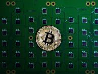Сувенирная монета биткоина на фоне электрических плат Сувенирная монета биткоина на фоне электрических плат