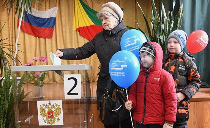 Женщина опускает бюллетень в урну на выборах президента Российской Федерации на избирательном участке в Чите. 18 марта 2018