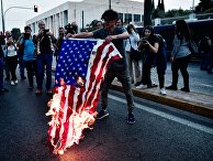 Сожжение флага США перед зданием посольства Сша в Афинах в Греции. 14 апреля 2018 Сожжение флага США перед зданием посольства Сша в Афинах в Греции. 14 апреля 2018