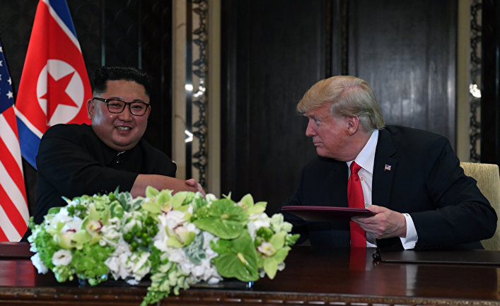Лидер КНДР Ким Чен Ын и президент США Дональд Трамп во время церемонии подписания документов по итогам встречи в Сингапуре. 12 июня 2018