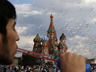 Молодой человек пускает мыльные пузыри на Красной площади в Москве Молодой человек пускает мыльные пузыри на Красной площади в Москве