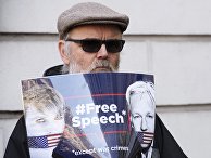 Мужчина стоит с плакатом в поддержку Джулиана Ассанжа в Лондоне Мужчина стоит с плакатом в поддержку Джулиана Ассанжа в Лондоне
