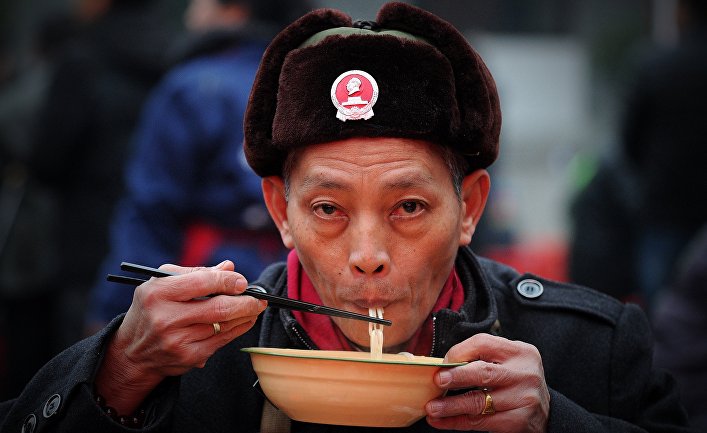 Человек ест лапшу в Шаошане, Китай Человек ест лапшу в Шаошане, Китай