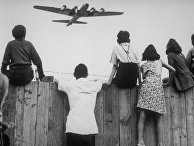 1 августа 1948. Дети из Западного Берлина смотрят, как в аэропорту Темпельхоф заходит на посадку самолет с продовольствием 1 августа 1948. Дети из Западного Берлина смотрят, как в аэропорту Темпельхоф заходит на посадку самолет с продовольствием
