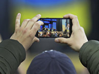 Мужчина фотографирует дебаты между Петром Порошенко у Владимиром Зеленским в Киеве Мужчина фотографирует дебаты между Петром Порошенко у Владимиром Зеленским в Киеве