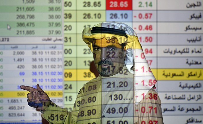 Трейдер говорит о ценах на нефть в банке в Эр-Рияде, Саудовская Аравия