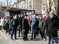Пассажиры на остановке общественного транспорта в Киеве, Украина Пассажиры на остановке общественного транспорта в Киеве, Украина