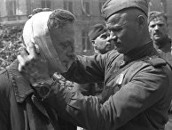 Великая Отечественная война 1941-1945 гг. Взятие Берлина Красной Армией. Советский солдат оказывает медицинскую помощь раненому местному жителю. Великая Отечественная война 1941-1945 гг. Взятие Берлина Красной Армией. Советский солдат оказывает медицинскую помощь раненому местному жителю.