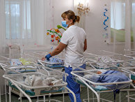 Медсестра в заботится о младенцах, рожденных суррогатными матерями в Киеве Медсестра в заботится о младенцах, рожденных суррогатными матерями в Киеве