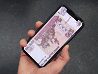 Денежная купюра на экране смартфона Денежная купюра на экране смартфона