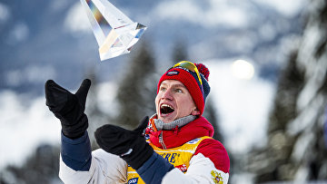 Александр Большунов (Россия), занявший первое место в общем зачете на соревнованиях по лыжным гонкам «Тур де Ски» среди мужчин в итальянском Валь-ди-Фьемме, на церемонии награждения