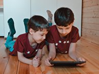 Дети играют в игру на планшетном компьютере Дети играют в игру на планшетном компьютере