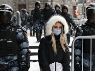 Жительница Москвы идет по Пушечной улице, огороженной сотрудниками правоохранительных органов перед началом несанкционированной акции сторонников Алексея Навального Жительница Москвы идет по Пушечной улице, огороженной сотрудниками правоохранительных органов перед началом несанкционированной акции сторонников Алексея Навального